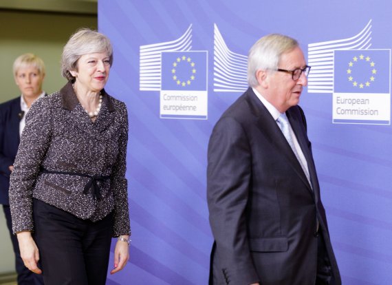 테리사 메이 영국 총리(왼쪽)가 11일(현지시간) 벨기에 브뤼셀에서 장 클로드 융커 유럽연합(EU) 집행위원장을 따라 회의장으로 이동하고 있다.신화연합뉴스