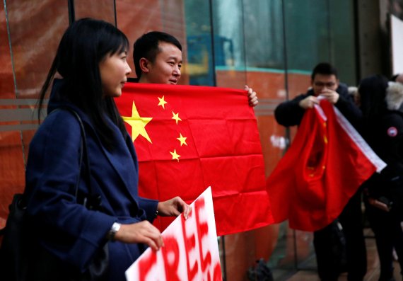 A man holds a Chinese flag outside the B.C. Supreme Court bail hearing of Huawei CFO Meng Wanzhou, who was held on an extradition warrant in Vancouver, British Columbia, Canada December 11, 2018. REUTERS/Lindsey Wasson <All rights reserved by Yonhap News Agency>