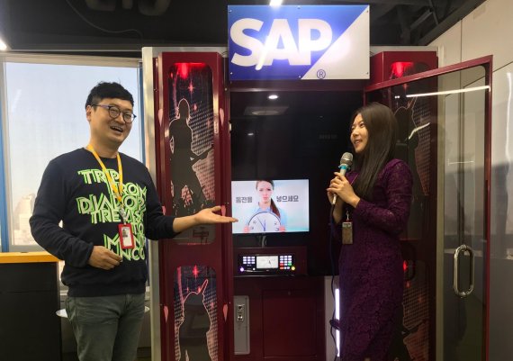 오용석 SAP 기업문화총괄 파트너(왼쪽)가 직원에게 SAP 코리아에 설치된 코인 노래방을 소개하고 있다. SAP코리아 제공