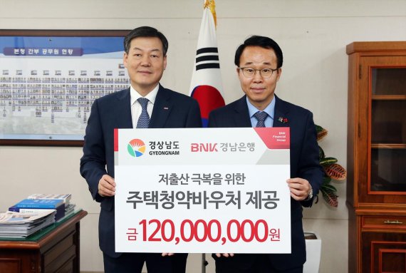 BNK경남은행유충렬 상무(왼쪽)가 경상남도 박성호 행정부지사에게 ‘주택 청약 바우처 제공 증서’를 전달하고 있다.