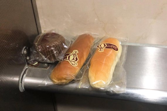 약수역 화장실에 포장이 채 벗겨지지 않은 빵이 놓여 있다. 사진=조재형 기자