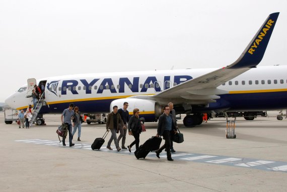 FILE - In this Wednesday, May 13, 2015 file photo, passengers disembark a Ryanair plane, at the Marseille Provence airport, in Marignane, southern France. Budget airline Ryanair is reducing its fleet and cancelling thousands of more flights as it struggles to overcome a pilot scheduling crisis. (AP 