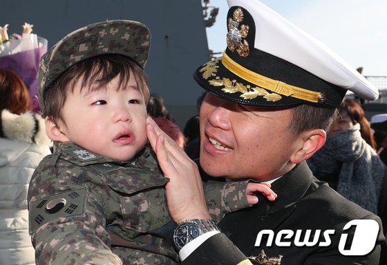 9일 오전 경남 창원시 진해 군항에서 열린 '해군 청해부대 27진 왕건함 입항 환영식'에서 부대원과 아이가 포옹을 하고 있다. 왕건함은 지난해 6월 출항해 200여일간 소말리아 해역에서 780여 척의 선박 안전 통항을 지원했다. 2019.1.9/뉴스1 © News1 여