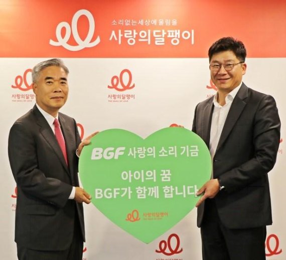 BGF 민승배 커뮤니케이션실장(오른쪽)이 사랑의달팽이 정해형 상임부회장에게 'BGF 사랑의 소리' 기금을 전달하고 있다.