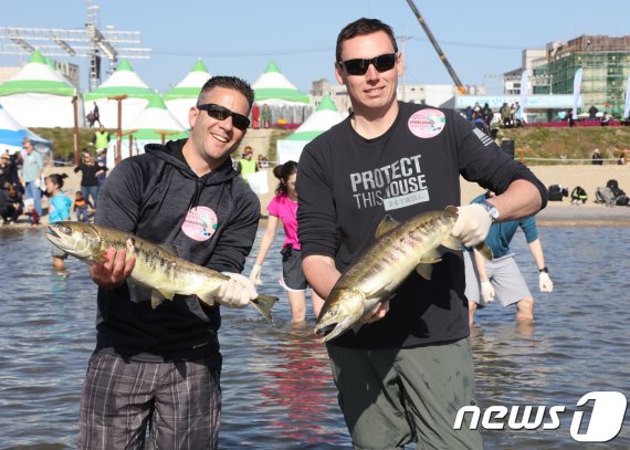 ‘2018양양연어축제’에 온 외국인들이 맨손으로 잡은 연어를 들어보이며 환하게 웃고 있다. (양양군 제공)