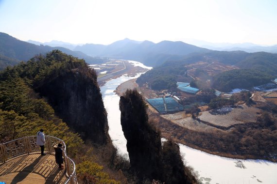 영월 서강 강변에 두갈래로 우뚝 선 기암 선돌을 전망대에서 관람객들이 바라보고 있다.