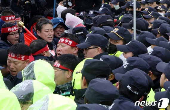 31일 오후 광주시청에서 광주시와 현대자동차공장 투자협약식이 진행되는 가운데 청사 앞에서 금속노조 조합원들이 광주형 일자리를 반대 결의대회 중 경찰통제선을 뚫고 청사로 진입을 시도하고 있다.2019.1.31/뉴스1 © News1 황희규 기자