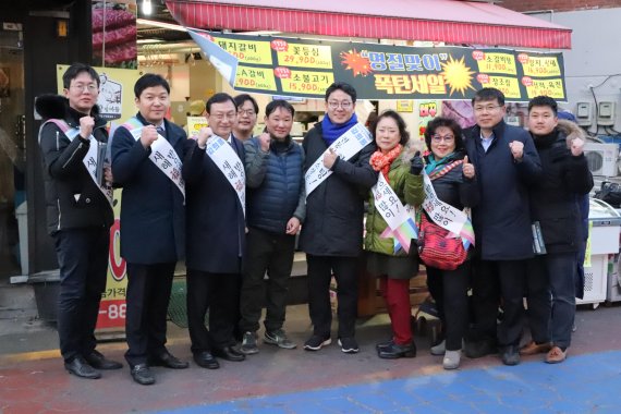 강희용 더불어민주당 동작구(을) 지역위원장(오른쪽에서 다섯번째)과 지역 시구의원 및 당원들이 설날 맞이 전통시장 방문 행사를 진행하고 있다.