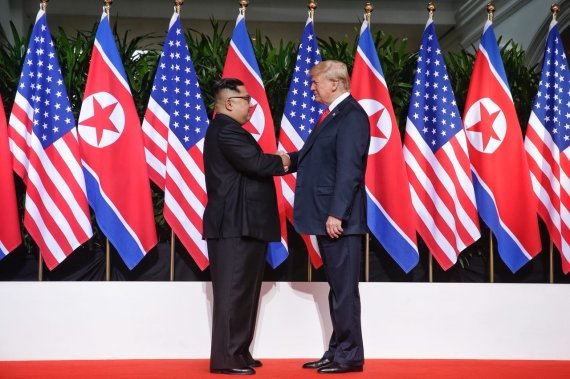 지난해 6월 12일 싱가포르에서 개최된 1차 북미정상회담에서 도널드 트럼프 미국 대통령(오른쪽)과 김정은 북한 국무위원장이 악수를 하고 있다.