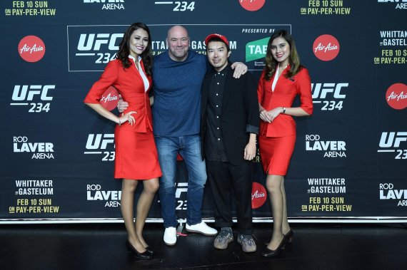 데이나 화이트(Dana White) UFC 대표(가운데 왼쪽)와 루디 카우(Rudy Khaw) 에어아시아 그룹 브랜딩 총괄 책임자(가운데 오른쪽)가 에어아시아 승무원들과 포즈를 취하고 있다. /사진=fnDB