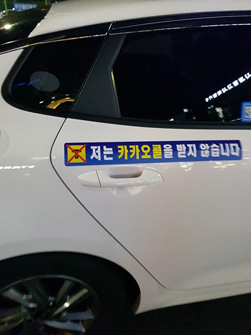 경기도 안양에서 택시 운전하는 기사 김모씨(53)의 택시. 뒷문 손잡이에 '저는 카카오콜을 받지 않습니다'라는 문구가 적힌 스티커가 붙여져 있다. 사진=오은선기자