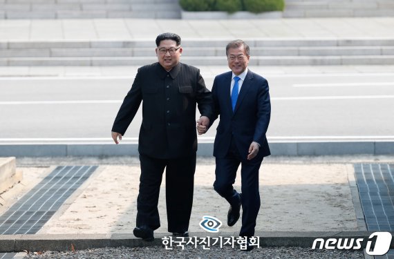 한국사진기자협회 제55회 한국보도사진상 대상에 동아일보 원대연 기자의 사진이 선정됐다. 지난해 4월 27일 문재인 대통령과 김정은 북한 국무위원장이 남북정상회담이 열린 판문점에서 만나 손을 잡고 함께 군사분계선을 넘는 모습. (한국사진기자협회 제공) 2019.2.18/