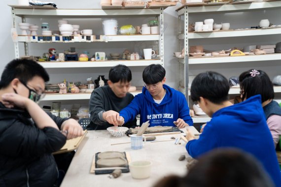 한국뉴욕주립대 2019년 신입생들이 오리엔테이션 프로그램 과정으로 20일 서울 우리마포복지관에서 발달장애인들과 도자기 만들기 활동을 하고 있다.