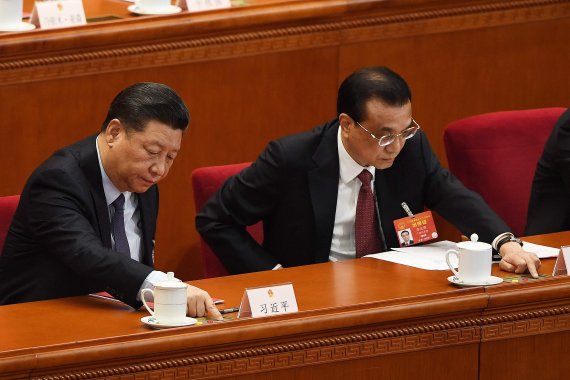 Chinese President Xi Jinping (L) and Premier Li Keqiang vote for foreign investment law to be passed during the closing session of the National People's Congress (NPC) in Beijing's Great Hall of the People on March 15, 2019. (Photo by Greg BAKER / AFP)<All rights reserved by Yonhap News Agency>
