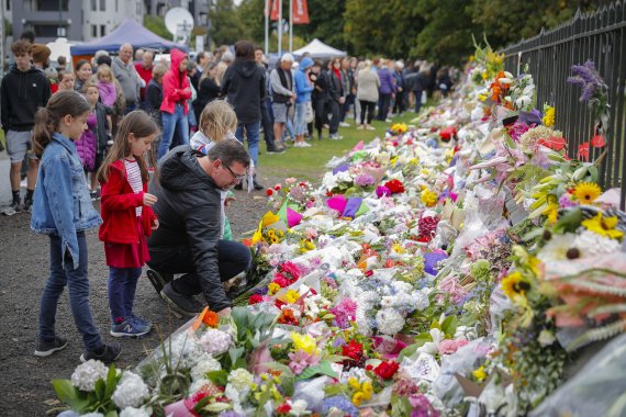17일 뉴질랜드 크라이스트처치의 보태니컬가든에서 이틀 전 발생한 총기 난사 사건을 추모하는 시민들이 꽃을 바치고 있다.AP연합뉴스