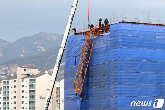 30일 오후 서울 은평구 서부경찰서 신축공사장에서 작업 중이던 타워크레인이 강풍에 꺾여 건물 위로 쓰러져 사고 수습작업이 이뤄지고 있다. 소방당국에 따르면 이날 사고로 인명 피해나 신축 공사 중인 건물에 대한 파손도 없는 것으로 파악됐다. 2019.3.30/뉴스1 ©