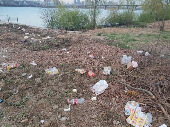 지난 8일 오후 여의도 공원 인근 흙 언덕에는 먹다남은 치킨 박스와 페트병 등이 널부러져 있었다/사진=이진혁 기자