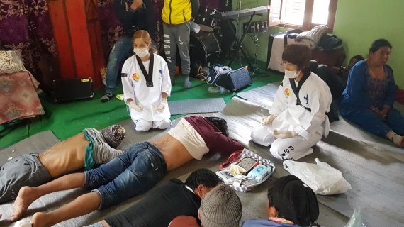 서번트미션팀 태권도 사범들이 의료 지원이 부족한 네팔 마을사람들에게 침술 봉사를 하고 있다. 서번트미션팀 제공