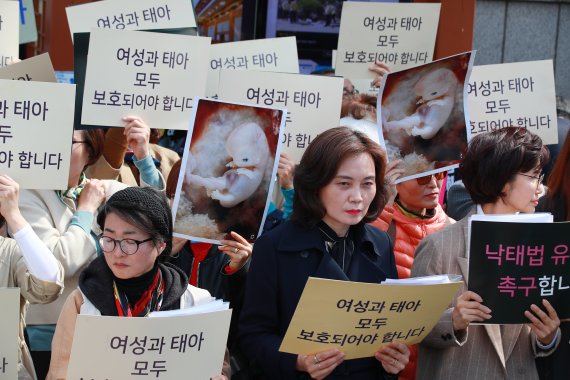 같은 시간 낙태죄폐지반대행동 단체 회원들이 낙태죄 합헌을 주장하는 내용의 손팻말을 들고 있다. 연합뉴스