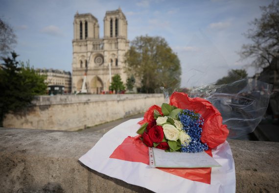 (190419) -- PARIS, April 19, 2019 (Xinhua) -- Flowers are presented to the cathedral of Notre Dame de Paris after a huge fire in Paris, France, April 18, 2019. French President, Emmanuel Macron, vowed to rebuild the cathedral after the inferno. In two days following the devastating blaze, nearly a b