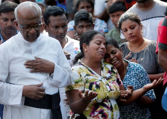 23일 스리랑카 수도 콜롬보에서 이틀 전 연쇄 테러로 사망한 희생자 유가족들이 장례식 가운데 오열하고 있다.로이터연합뉴스
