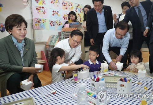 3일 서울 관악구에 위치한 첫 공립 전환 유치원인 구암유치원을 찾은 더불어민주당 이해찬 대표(오른쪽)와 홍영표 원내대표가 어린이들에게 선물을 주고 있다.