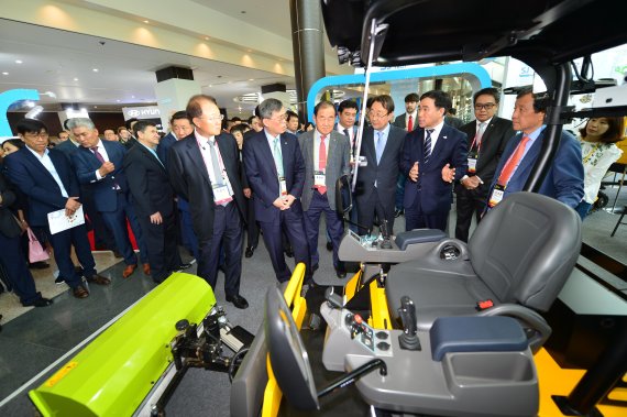 제6회 국제전기차엑스포에서 컨퍼런스 참석자들이 전시장에서 친환경 고효율의 농업용 전기차량을 둘러보고 있다.