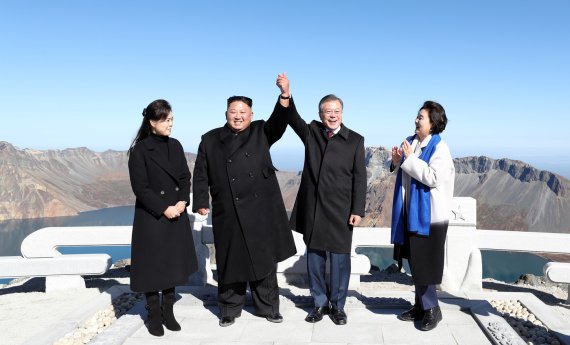 2018년 9월 20일 오전 문재인 대통령과 김정은 북한 국무위원장이 백두산 정상인 장군봉에 올라 손을 맞잡아 들어 올리고 있다. 김정숙 여사와 리설주 여사도 함께 했다. (사진: 평양사진공동취재단)