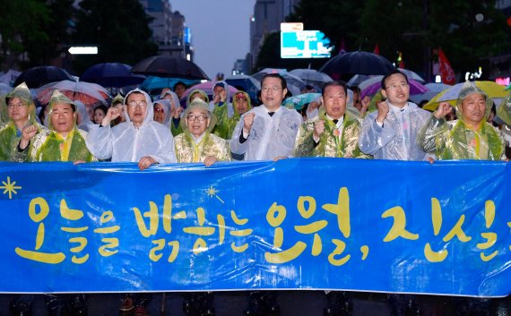 이용섭 광주광역시장이 지난 17일 오후 동구 금남로에서 열린 제39주년 5·18민중항쟁 기념 전야제에 참석하기 위해 5·18단체, 주요 기관, 정당, 시민사회단체 관계자 등과 함께 광주일고 사거리에서 금남로 전일빌딩 앞까지 쏟아지는 비를 맞으며 민주평화대행진을 펼치고 있다.사진=광주광역시 제공