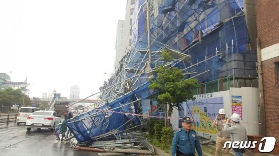 27일 낮 12시28분쯤 부산 중구 중앙동의 한 건설현장에 설치된 대형 외벽 안전펜스가 추락했다. 안전펜스가 도로를 점령한 모습.(부산지방경찰청 제공)© 뉴스1