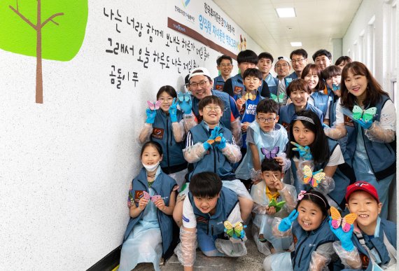 한국투자증권 참벗나눔 봉사단원들이 25일 녹번종합사회복지관을 방문해 '벽화그리기' 봉사활동을 진행하고 기념촬영을 하고 있다. 한국투자증권 제공