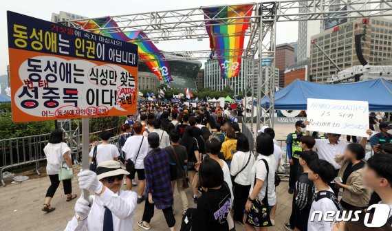 퀴어문화축제가 열리는 행사장 입구에 축제 반대 피켓을 든 사람이 서있다. /사진=뉴스1
