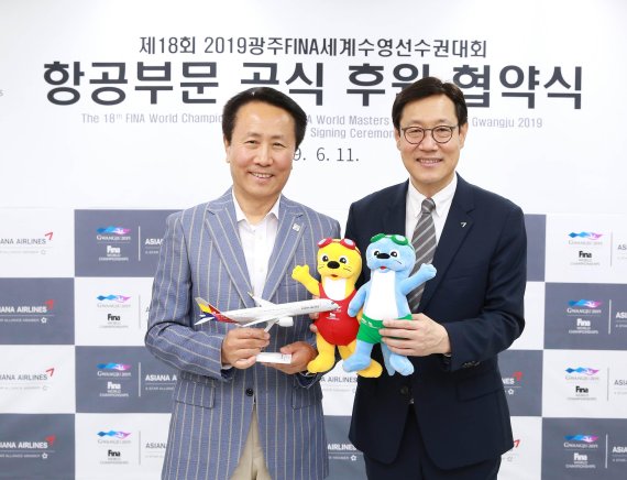 11일 광주세계수영선수권대회 조직위원회에서 진행된 '2019광주FINA세계수영선수권대회 항공부문 공식 후원 협약식'에서 아시아나항공 김영헌 여객본부장(오른쪽)과 조직위원회 조영택 사무총장(왼쪽)이 기념촬영을 하고 있다. /사진=아시아나항공