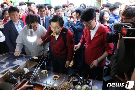 황교안 자유한국당 대표(가운데)와 장제원 의원(오른쪽)이 지난달 7일 오후 부산 사상구 덕포시장에서 어묵을 먹고 있다.