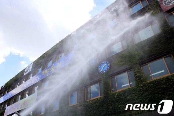 광주 북구청이 청사내부 온도를 낮추기 위해 살수차를 이용해 청사외벽에 물을 뿌리고 있다/뉴스1