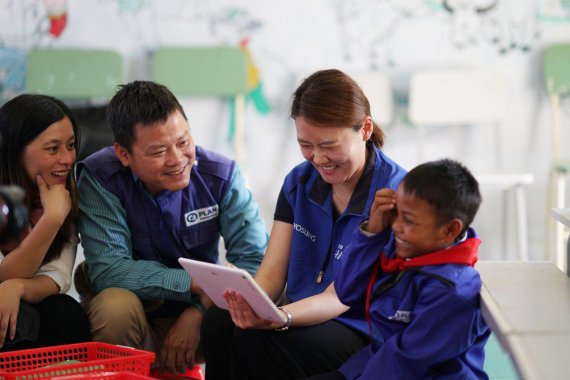 효성이 지난 4월 베트남 중부의 자매결연마을인 꼰촛 마을을 방문해 초등학교를 지어 선물하는 준공행사를 진행했다. 효성 임직원들과 마을 어린이가 후원자의 응원 메시지를 보고 웃고 있다.효성 제공
