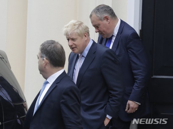 차기 영국 총리 경쟁에서 선두를 달리고 있는 보리스 존슨 전 외무장관(가운데)이 12일(현지시간) 영국 런던에서 연설을 마친 후 떠나고 있다. 영국 하원은 이날 노딜 브렉시트를 막기 위한 법률안을 부결시켰다.AP뉴시스