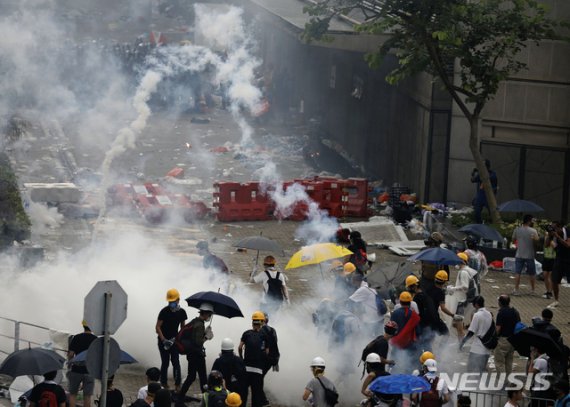 홍콩 경찰들이 12일 입법원 근처 도로에서 범죄인 인도법 반대 시위대를 향해 최루탄을 쏘고 있다.2019.06.12 /사진=뉴시스
