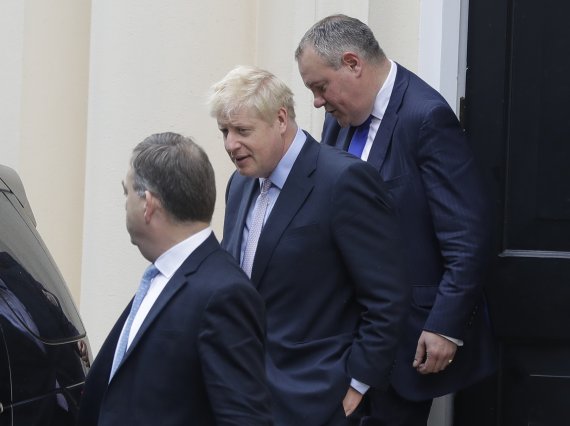 차기 영국 총리 경쟁에서 선두를 달리고 있는 보리스 존슨 전 외무장관(가운데)이 12일(현지시간) 영국 런던에서 연설을 마친 후 떠나고 있다. AP뉴시스