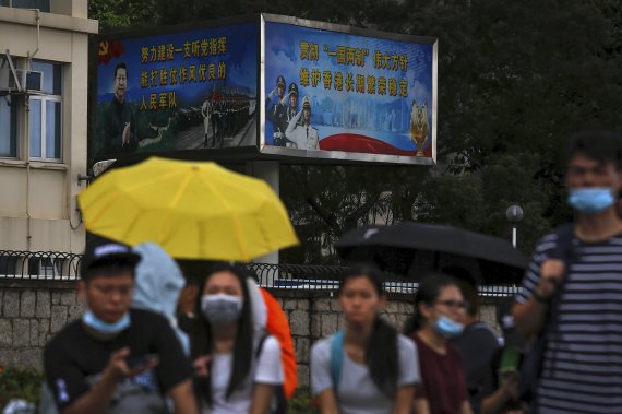 Protesters with umbrellas gather near billboards carrying a photo of Chinese President Xi Jinping and Chinese People's Liberation Army (PLA) near the Legislative Council as they continue to protest against the unpopular extradition bill in Hong Kong, Monday, June 17, 2019. (AP Photo/Kin Cheung) /뉴시스