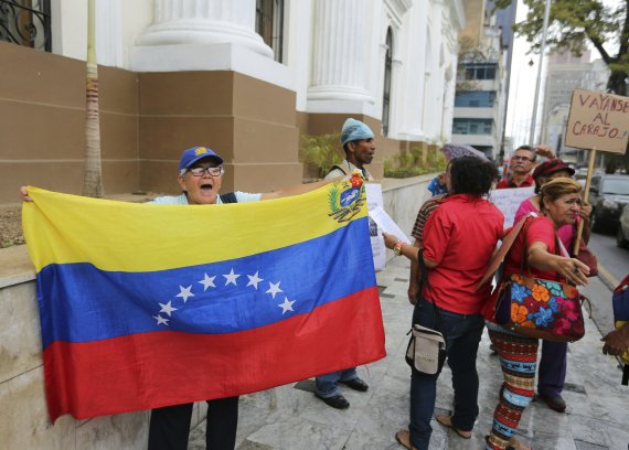 지난 6월 18일, 베네수엘라 수도 카라카스의 국회 건물 앞에서 니콜라스 마두로 대통령을 지지하는 시위대가 야당 의원들에게 욕설을 퍼붓고 있다.AP뉴시스