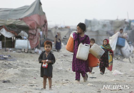 전쟁과 기근을 피해 아프간을 떠나온 아프간 난민들이 파키스탄 라호르 빈민가에서 물을 받으러 가고 있다. 파키스탄은 고국에서 탈출할 수밖에 없었던 난민들의 용기를 기리며 유엔난민기구가 6월 20일로 정한 '세계 난민의 날'을 준수한다. 2019.06.20. /사진=뉴시스