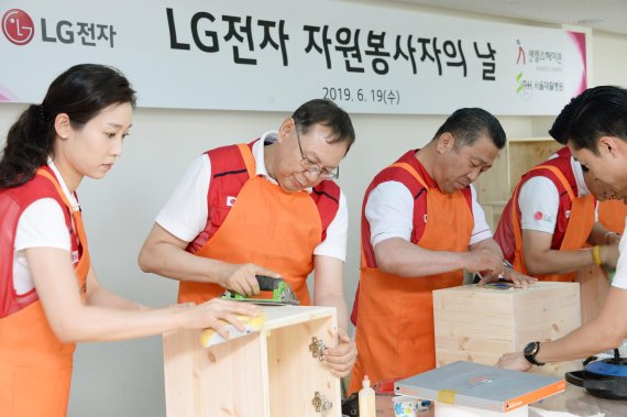 LG전자 대표이사 최고경영자(CEO) 조성진 부회장(왼쪽 두번째), 배상호 노조위원장(왼쪽 세번째)이 재활원에 전달할 가구를 만들고 있다. LG전자 제공