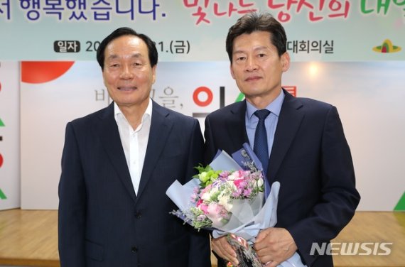 【의성=뉴시스】 김진호 기자 = 김주수(왼쪽) 의성군수가 명예퇴임하는 김용우 관광경제국장에게 공로패와 꽃다발을 전달하고 있다. 2019.06.21 (사진=의성군 제공) photo@newsis.com