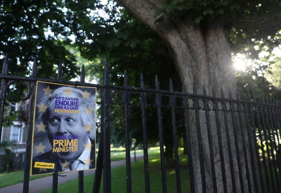 A poster depicting PM hopeful Boris Johnson hangs on a fence of the park opposite to his house in London, Britain June 22, 2019.