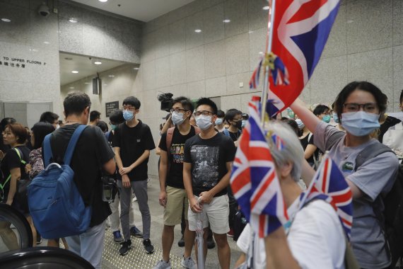 홍콩 도심의 레비뉴타워에서 24일 홍콩 경찰의 시위 강경 진압에 반대하는 시위대가 영국 국기를 들고 로비를 점거하고 있다.AP뉴시스