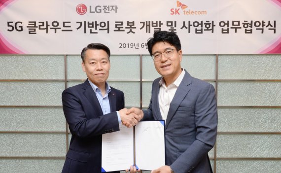 LG전자 노진서 로봇사업센터장(왼쪽)과 SK텔레콤 박진효 ICT기술센터장이 25일 서울 금천구에 위치한 가산R&D캠퍼스에서 공동 연구개발을 위한 양해각서(MOU)를 체결한 뒤 악수하고 있다. LG전자 제공