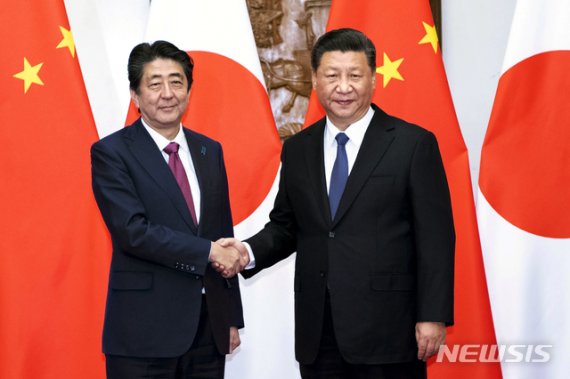 시진핑(習近平) 중국 국가주석(오른쪽)과 아베 신조(安倍晋三) 일본 총리가 2018년 10월 26일 중국 베이징(北京)에 위치한 영빈관 댜오위타이(釣魚台)에서 회담을 열기 전 악수를 나누고 있다.