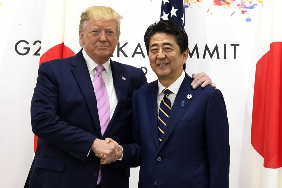 지난 6월 28일 일본 오사카에서 열린 주요 20개국(G20) 정상회의에서 도널드 트럼프 미국 대통령(왼쪽)이 아베 신조 일본 총리와 악수하고 있다.AP뉴시스