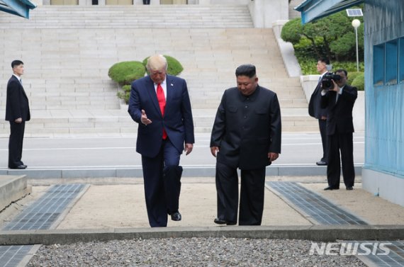 도널드 트럼프 미국 대통령과 김정은 북한 국무위원장이 30일 판문점 공동경비구역(JSA) 군사분계선을 넘어 북측으로 갔다 다시 남측으로 넘어오고 있다.